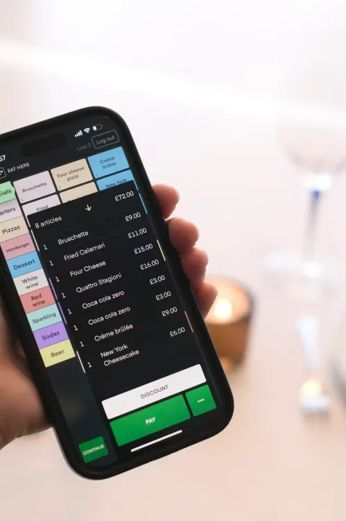 A hand holding a smartphone with the POS showing