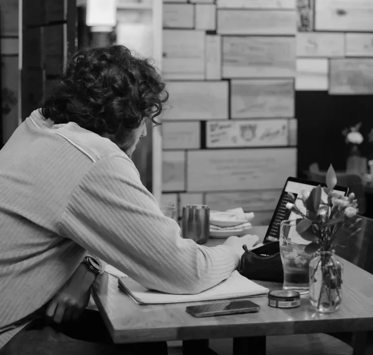 Man sitting with a laptop in a restaurant