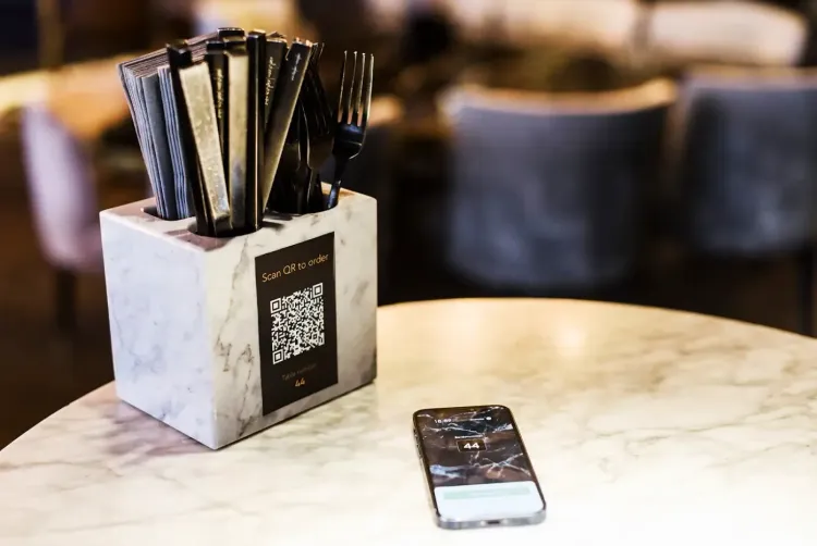A table with QR code and a phone showing the online ordering